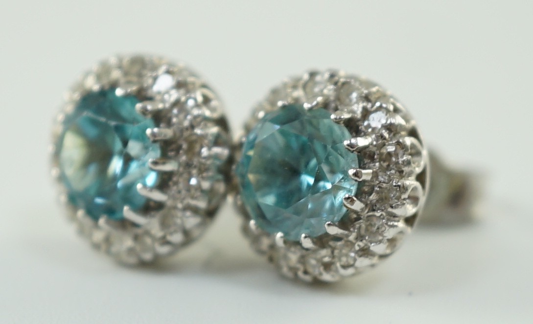 A pair of 18k white gold, blue zircon and diamond set circular cluster ear studs